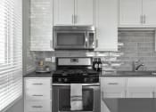 Thumbnail 2 of 30 - a black and white kitchen with a stove and a microwave at Park 205, Park Ridge, 60068