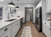 Thumbnail 2 of 79 - a kitchen with white cabinets and a stainless steel refrigerator at The Commons at Rivertown, Grandville