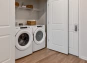 Thumbnail 6 of 42 - a washer and dryer in a laundry room with white doors at The View on Collins, Lansing, MI