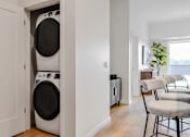 Thumbnail 73 of 83 - A white washing machine is in a small laundry room.