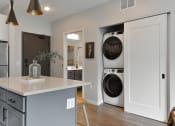 Thumbnail 4 of 76 - a kitchen with a washing machine and a dryer in it at The Lodge at Overland, Rochester, Minnesota
