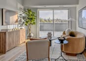Thumbnail 74 of 83 - A living room with a brown chair and a small table.