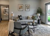 Thumbnail 3 of 79 - a living room with a couch and a table at The Commons at Rivertown, Grandville, MI
