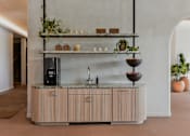 Thumbnail 34 of 83 - A modern kitchen with a wooden counter and a black fridge.