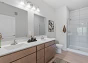 Thumbnail 23 of 62 - a bathroom with two sinks and a shower and a toilet at The Aurilla, Cottage Grove, MN