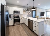 Thumbnail 45 of 79 - a large kitchen with white cabinets and stainless steel appliances at The Commons at Rivertown, Grandville, MI, 49418