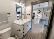 Thumbnail 53 of 79 - a bathroom with a large mirror and a toilet and a sink at The Commons at Rivertown, Grandville, Michigan, 49418
