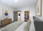 Thumbnail 55 of 79 - a bedroom with a bed and a dresser and a closet at The Commons at Rivertown, Grandville