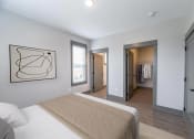 Thumbnail 66 of 79 - a bedroom with a large bed and a walk in closet at The Commons at Rivertown, MI