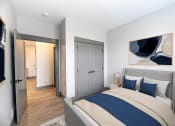 Thumbnail 72 of 79 - a bedroom with a bed and a door to a bathroom at The Commons at Rivertown, Grandville, MI, 49418