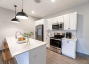 Thumbnail 32 of 79 - a kitchen with white cabinets and stainless steel appliances at The Commons at Rivertown, Grandville, MI