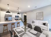 Thumbnail 34 of 79 - an open living room and kitchen with a table and chairs at The Commons at Rivertown, Grandville, MI, 49418