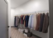 Thumbnail 39 of 79 - a closet with a rack of clothes and a door to a room with a wardrobe at The Commons at Rivertown, Michigan