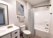 Thumbnail 42 of 79 - a bathroom with a shower and a toilet and a sink at The Commons at Rivertown, Grandville, MI, 49418