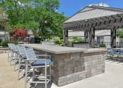 Thumbnail 16 of 30 - a patio with a bar and chairs and a gazebo