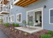 Thumbnail 12 of 76 - a patio with a chair and a table in front of a house at The Lodge at Overland, Rochester, MN, 55901