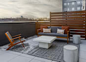 Thumbnail 83 of 83 - A wooden chair and a white table are on a patio.
