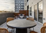 Thumbnail 82 of 83 - A patio with a table and chairs is set up on a balcony.