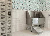 Thumbnail 27 of 79 - a large stainless steel sink in a bathroom with tiled walls at The Commons at Rivertown, Grandville