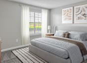 Thumbnail 6 of 43 - A bedroom with a large bed and a window with blinds.