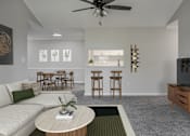 Thumbnail 13 of 43 - A living room with a white couch, a round table, and a ceiling fan.