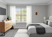 Thumbnail 14 of 43 - A bedroom with a large bed and a window with white curtains.