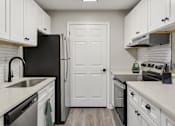 Thumbnail 9 of 43 - A kitchen with black appliances and white cabinets.