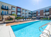 Thumbnail 14 of 30 - a swimming pool with an apartment building in the background at Park 205, Park Ridge, 60068