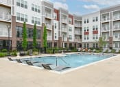 Thumbnail 35 of 42 - a swimming pool in front of an apartment building at The View on Collins, Lansing, Michigan