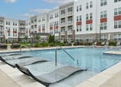 Thumbnail 37 of 42 - a swimming pool in front of an apartment building at The View on Collins, Lansing, 48910
