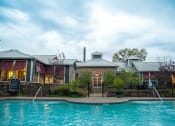 Thumbnail 29 of 43 - a swimming pool in front of a brick building with a metal roof  at Riverset Apartments, Tennessee