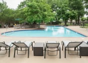 Thumbnail 42 of 43 - a swimming pool with lounge chairs and trees in the background  at Riverset Apartments, Memphis
