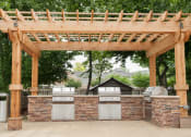 Thumbnail 41 of 43 - an outdoor kitchen with a pergola and barbecue  at Riverset Apartments, Tennessee, 38103