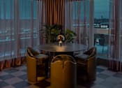 Thumbnail 63 of 83 - A round table with four chairs is in the middle of a room with a checkered floor.