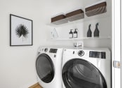 Thumbnail 16 of 83 - a washer and dryer in a laundry room with a picture on the wall