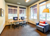 Thumbnail 40 of 43 - a desk with two computers and a chair in a room with large windows  at Riverset Apartments, Memphis