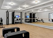 Thumbnail 52 of 83 - A gym with a variety of equipment including a treadmill, a stationary bike, a rowing machine, a squat rack, a bench press, a cable machine, a leg press, a pull up bar, a