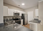 Thumbnail 15 of 19 - A kitchen with a stove, oven, refrigerator, and microwave.