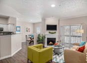 Thumbnail 4 of 19 - A living room with a yellow chair and a fireplace.