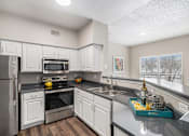 Thumbnail 1 of 19 - A kitchen with white cabinets and a black stove top.