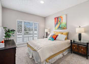 Thumbnail 8 of 19 - A bedroom with a bed, nightstands, and a painting on the wall.