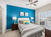 Thumbnail 7 of 19 - A bedroom with a bed, two lamps, and two pictures on the wall.