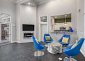 Thumbnail 16 of 19 - A living room with a fireplace and blue chairs.