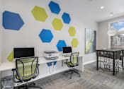 Thumbnail 19 of 19 - A room with a desk, chairs and a wall with hexagonal shapes on it.
