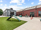 Thumbnail 8 of 17 - A playground with a green slide and a red fire hydrant.