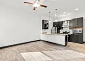 Thumbnail 2 of 21 - A modern kitchen with a white island and black cabinets.