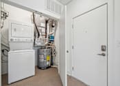 Thumbnail 8 of 9 - A white door is open to a hallway with a washer and dryer in the background.