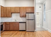 Thumbnail 3 of 9 - a kitchen with wooden cabinets and a stainless steel refrigerator