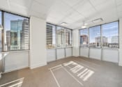 Thumbnail 4 of 9 - A spacious room with large windows overlooking a cityscape.