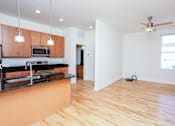 Thumbnail 13 of 21 - A kitchen with wooden floors and a black counter top.